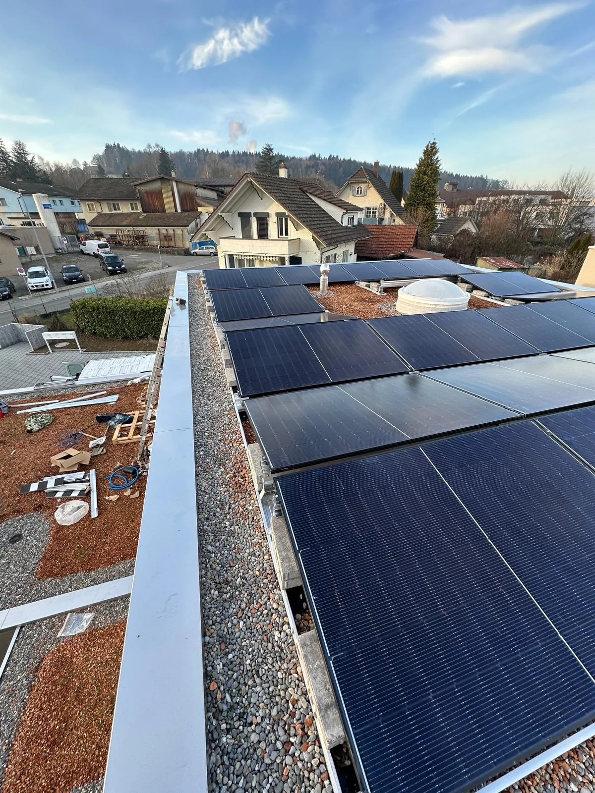 Aufgeständerte Solarmodule auf einem Flachdach bei Tageslicht